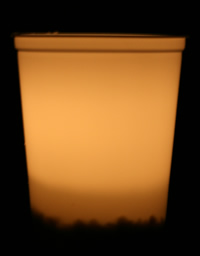 white bucket with lit candle